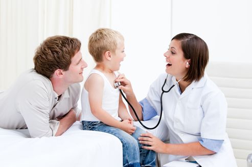 Radiant female doctor examining a little boy with his father